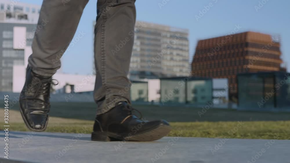 Unrecognized businessman legs walking on street. Worker feet going on street Unrecognized businessman legs walking on street. Worker feet going on street