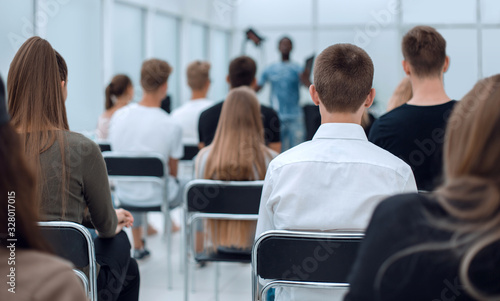 rear view. a group of diverse young people sitting in a conference room.