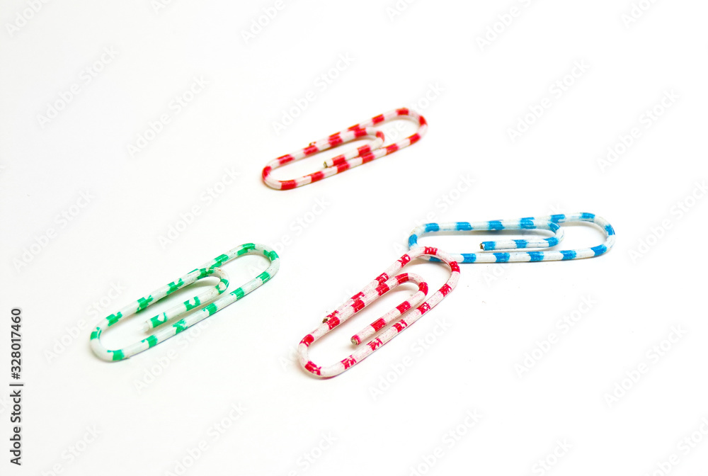 Paper clips of different colors isolated on a white background. Office paper clips for binding documents and sheets of paper. Metal clips. Paper clips of different colors isolated on a white background. Office paper clips for binding documents and sheets of paper. Metal clips.