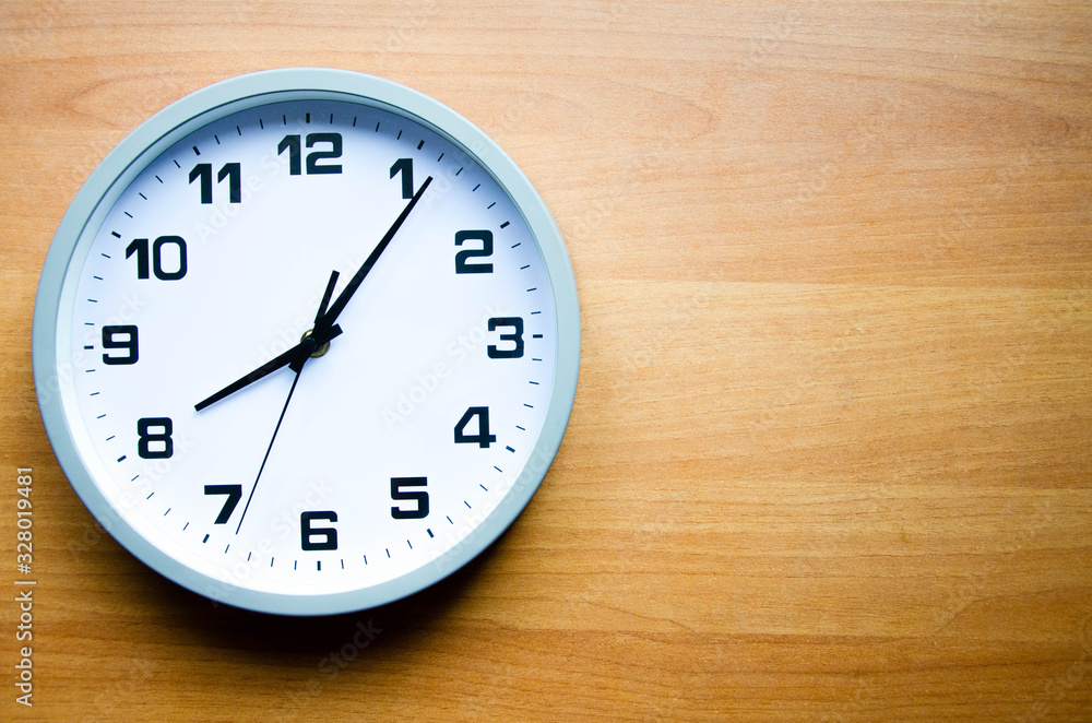 Analog clock on a wooden background. The watch is large in color and black and white. View from above. The clock is 20:05, 08:05. Copy Space Analog clock on a wooden background. The watch is large in color and black and white. View from above. The clock is 20:05, 08:05. Copy Space