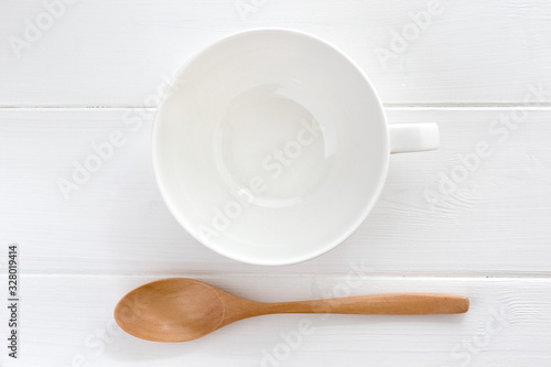 白のスープのカップと木製のスプーン