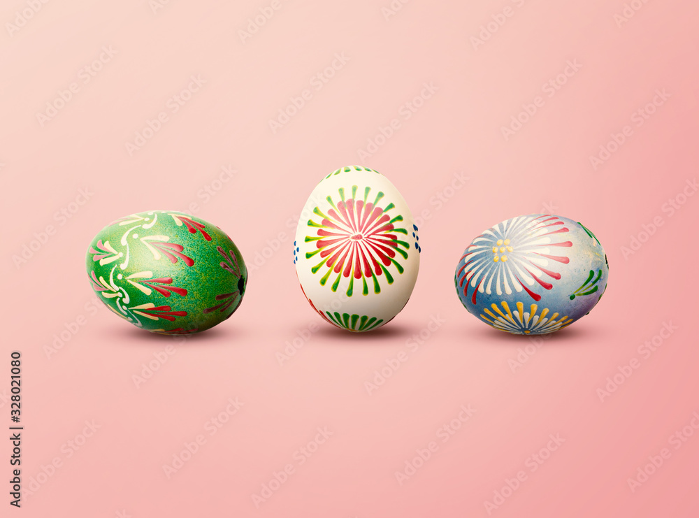 Green, White and Blue Painted Handmade Easter Eggs on Pink Background