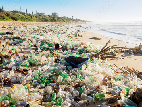 Plastic bottles washed up on beach by the incoming tide cover the entire beach photo