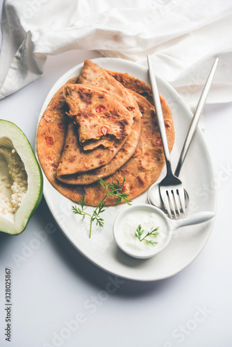 Raw Papaya Paratha or Papita ke Parathe made using Made using papaya, wheat flour, cumin seeds, ginger. Popular Indian food recipe served hot with curd. selective focus photo