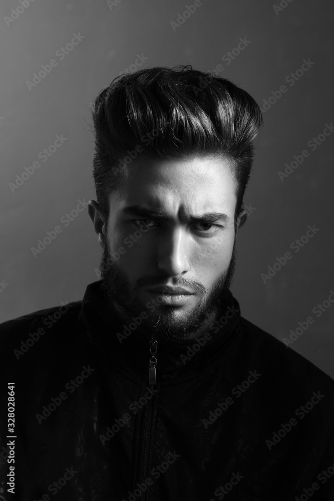 Close-up black and white portrait of a young handsome Caucasian male in studio. A man shows different human emotions. Close-up black and white portrait of a young handsome Caucasian male in studio. A man shows different human emotions.