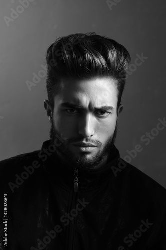 Close-up black and white portrait of a young handsome Caucasian male in studio. A man shows different human emotions.