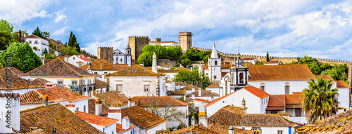 Φωτογραφία Old town skyline of Obidos, Portugal with house roof tops, church towers and the wall of the medieval castle located in the civil parish of Santa Maria, São Pedro e Sobral da Lagoa,  Oeste region