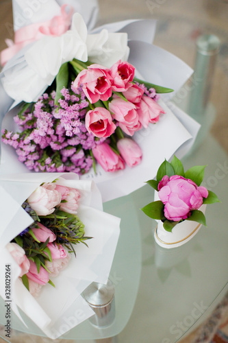 Three bouquets of pink flowers and some greenery