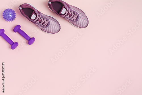 Sports equipment for women's training in pastel colored. Pink background.