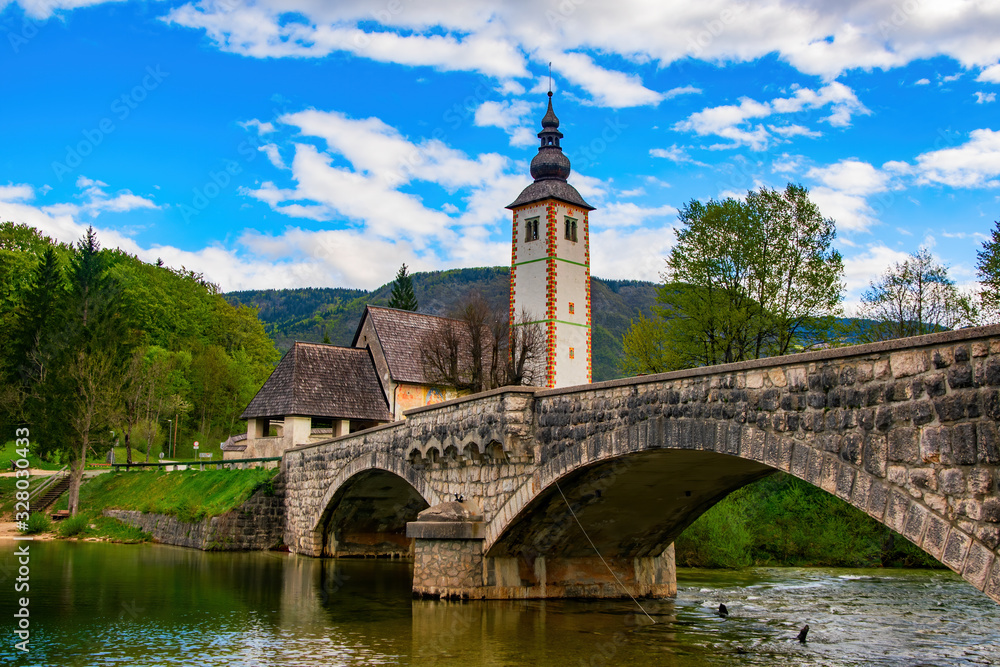 Scenic view of stone bridge and church of St John the Baptist on Bohinj Lake, Slovenia