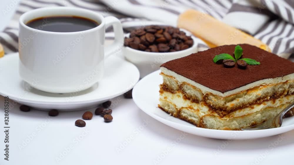 Tiramisu dessert square portion, savoiardi cookies and cup of coffee isolated on white background Tiramisu dessert square portion, savoiardi cookies and cup of coffee isolated on white background