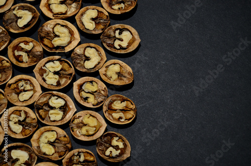 halves of inshell walnut on the left edge close-up on a gray background horizontal orientation © Svetlana
