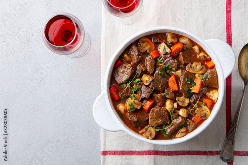 Beef bourguignon stew with vegetables and red wine. Grey background. Top view.