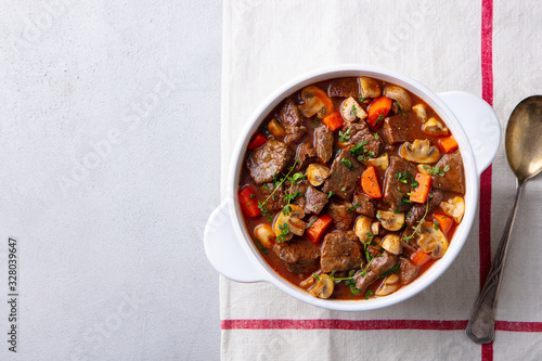 Beef bourguignon stew with vegetables. Grey background. Copy space. Top view. photo
