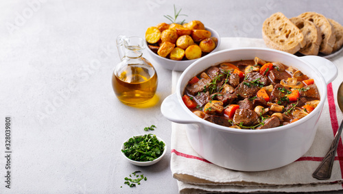 Beef bourguignon stew with vegetables. Grey background. Copy space. photo