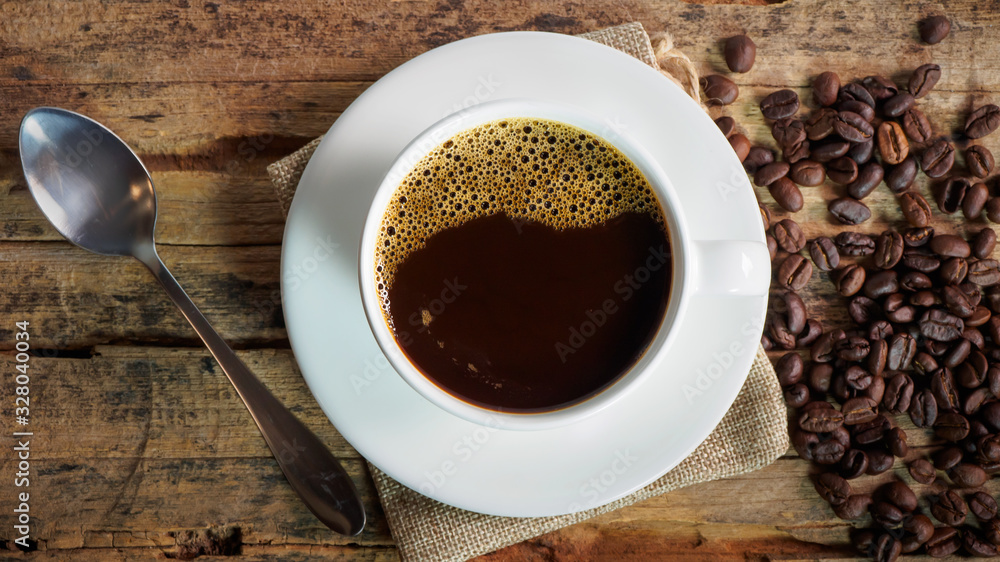 Coffee cups and coffee beans roasted on a wooden table Coffee cups and coffee beans roasted on a wooden table