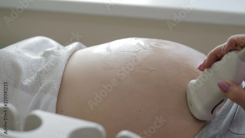 Close-up view of the doctor doing ultrasound to a pregnant woman photo