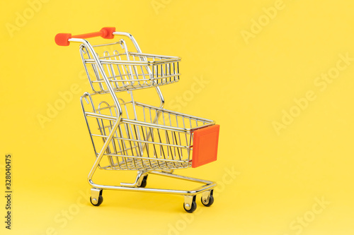 Double baskets shopping cart or shopping trolley on yellow background using as online shopping, e-commerce, supermarket consumer purchase concept