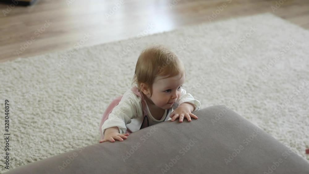 Smiling young father and mother helping their cute little daughter to climb on sofa in room. Parenthood and family concept. Life camera Smiling young father and mother helping their cute little daughter to climb on sofa in room. Parenthood and family concept. Life camera