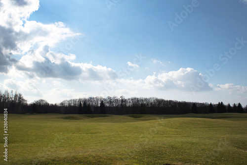 Golf course against the sky with white clouds in early spring © Lyudmyla