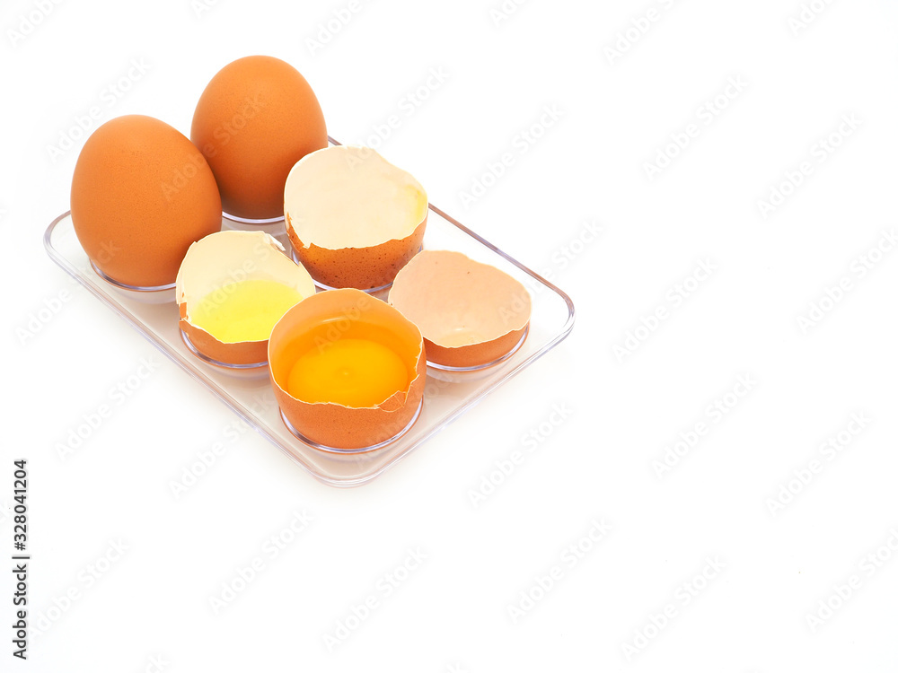 Fresh half-cracked egg in plastic trays isolated on white background. Fresh half-cracked egg in plastic trays isolated on white background.