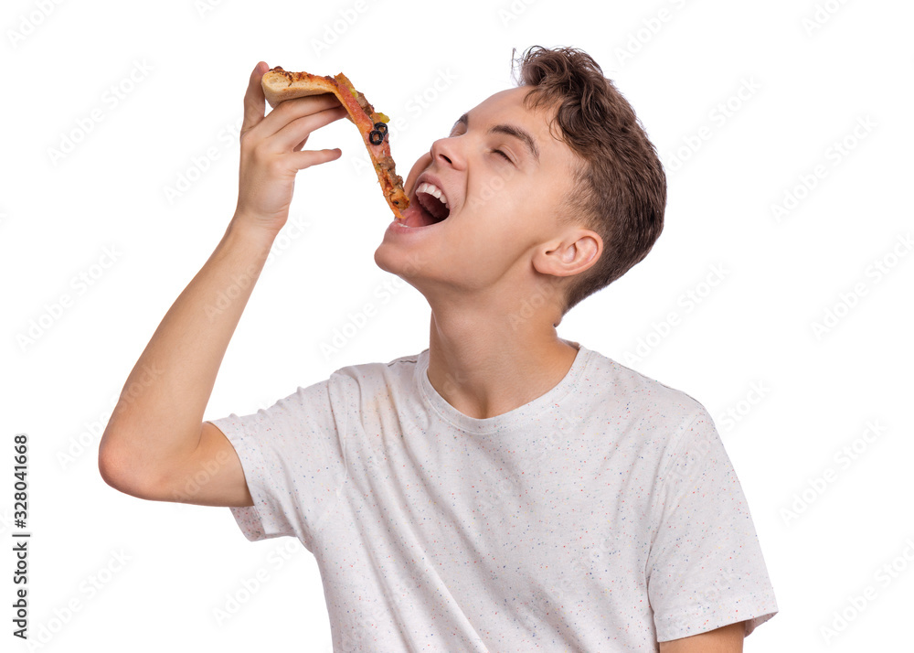 Happy beautiful young teen boy appetizing bites slice of pizza. Close up portrait of child with delicious Italian pizza, isolated on white background. Guy eating fast food.
