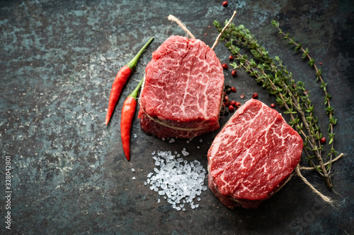 Foto Two juicy filet Mignon beef steaks prepared for grilling with spices and herbs,