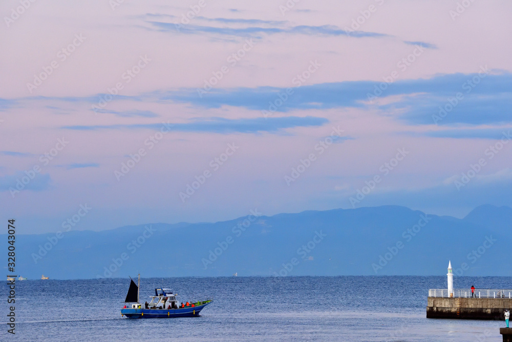 早朝に片瀬漁港から出航する釣り船