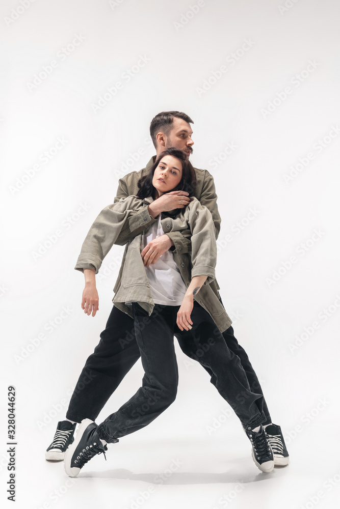 Supporting. Trendy fashionable couple isolated on white studio background. Caucasian woman and man posing in basic minimal stylish clothes. Concept of relations, fashion, beauty, love. Copyspace. Supporting. Trendy fashionable couple isolated on white studio background. Caucasian woman and man posing in basic minimal stylish clothes. Concept of relations, fashion, beauty, love. Copyspace.