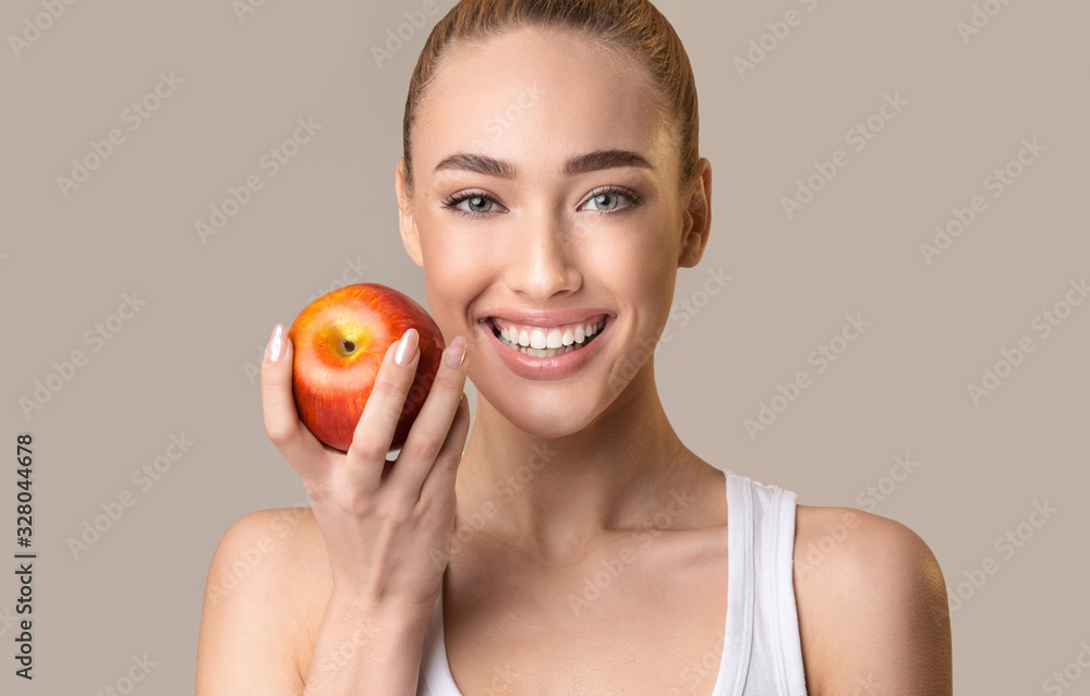 Happy Woman Holding Apple Near Face Posing On Beige Background Happy Woman Holding Apple Near Face Posing On Beige Background