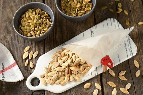 Roasted pumpkin seeds on a wooden background.