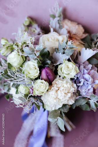 Rich bunch of pink peonies and lilac eustoma roses flowers, green leaf in glass vase. Fresh spring bouquet. Summer Background