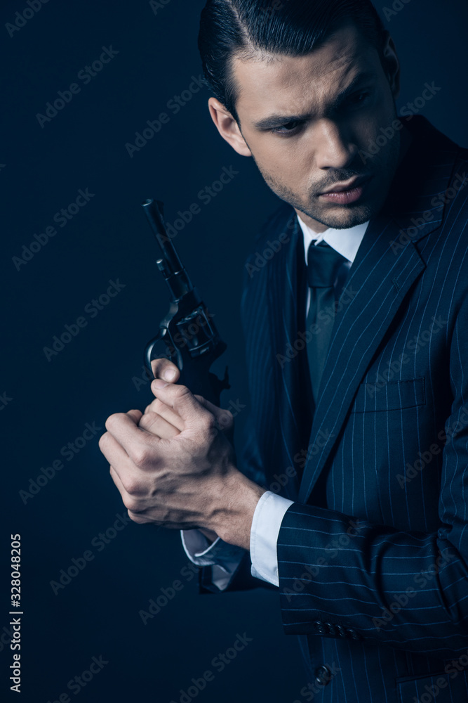Naklejka premium Gangster holding weapon with clenched hands on dark blue