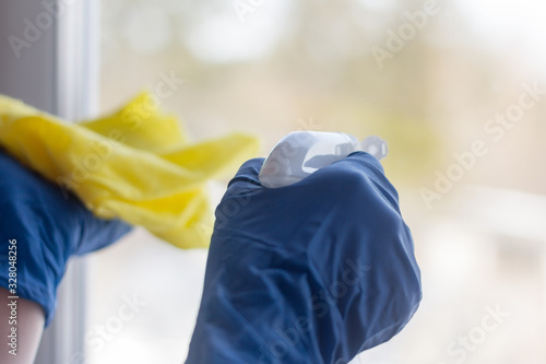Seasonal cleaning of the house.Women's gloved hands wash the window.