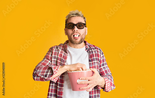 Excited man in 3d glasses filled his mouth popcorn photo