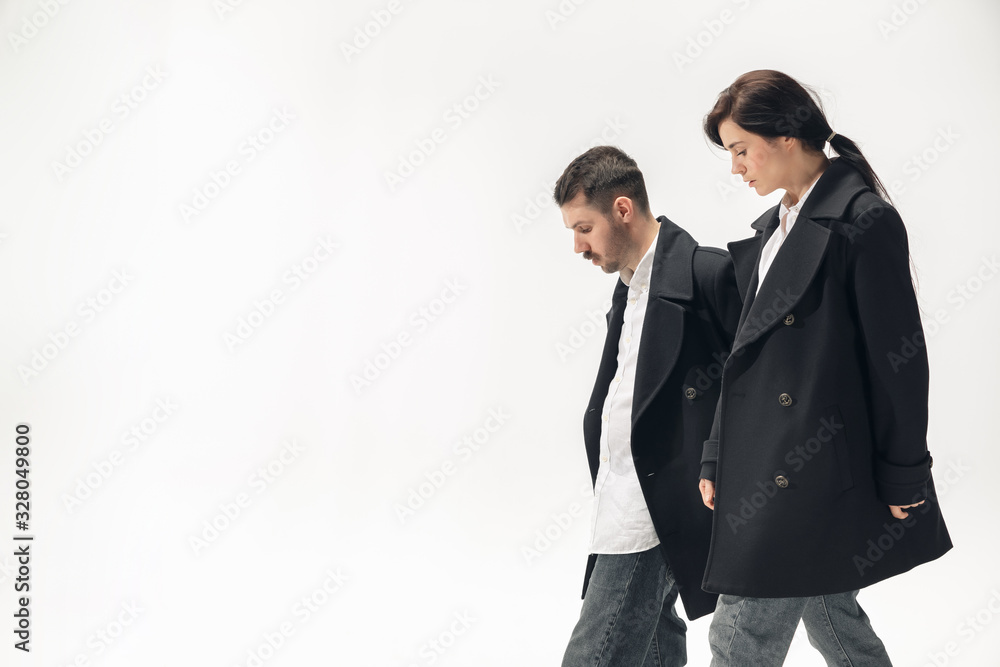 Warmth. Trendy fashionable couple isolated on white studio background. Caucasian woman and man posing in basic minimal black stylish clothes. Concept of relations, fashion, beauty, love. Copyspace. Warmth. Trendy fashionable couple isolated on white studio background. Caucasian woman and man posing in basic minimal black stylish clothes. Concept of relations, fashion, beauty, love. Copyspace.