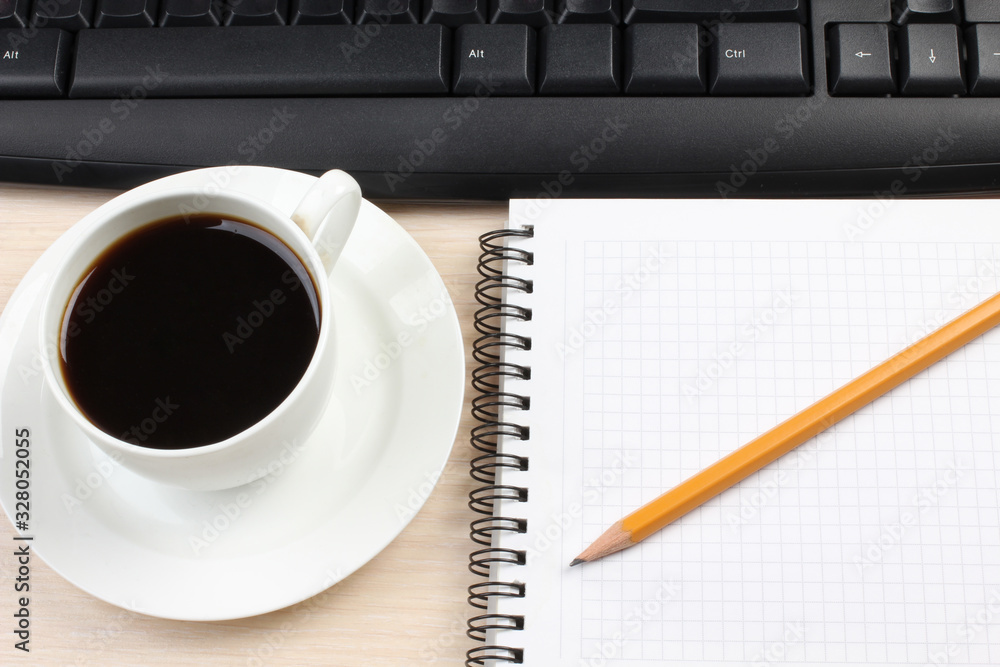 Ceramic cup with coffee and a computer keyboard on a wooden table Ceramic cup with coffee and a computer keyboard on a wooden table