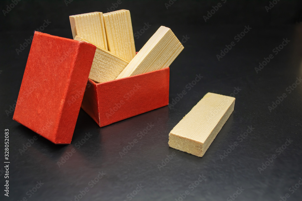 Wooden blocks in a red box on a black background