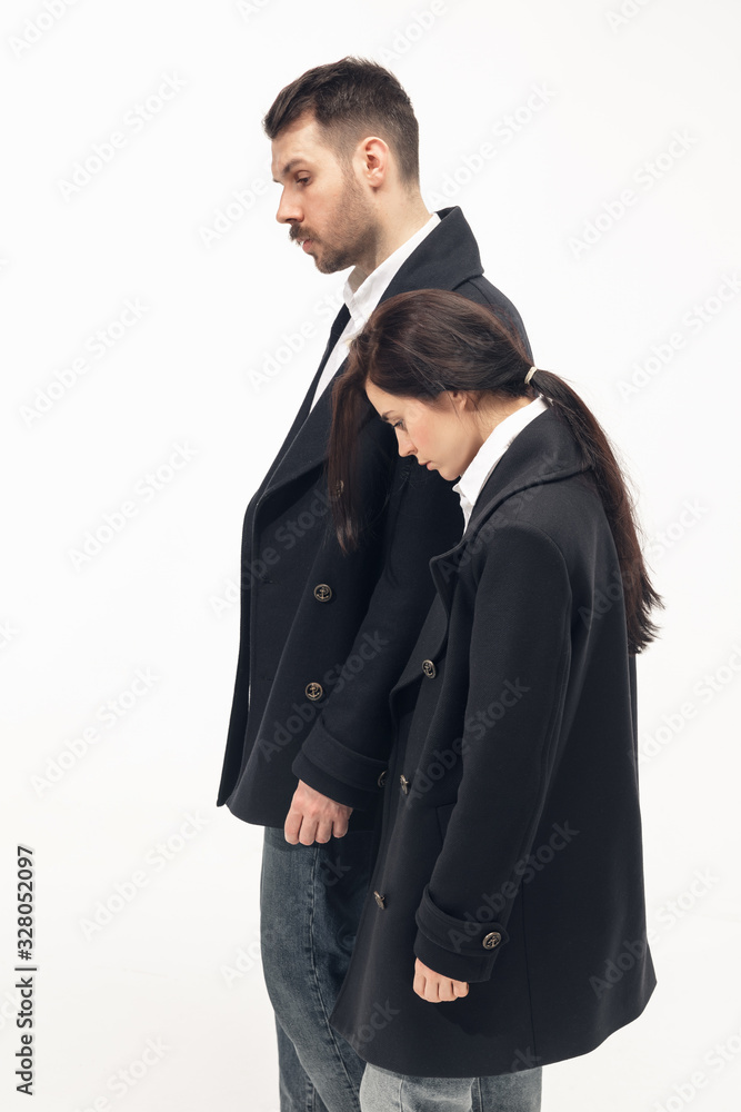 Memory creating. Trendy fashionable couple isolated on white studio background. Caucasian woman and man posing in basic minimal black stylish clothes. Concept of relations, fashion, beauty, love. Memory creating. Trendy fashionable couple isolated on white studio background. Caucasian woman and man posing in basic minimal black stylish clothes. Concept of relations, fashion, beauty, love.
