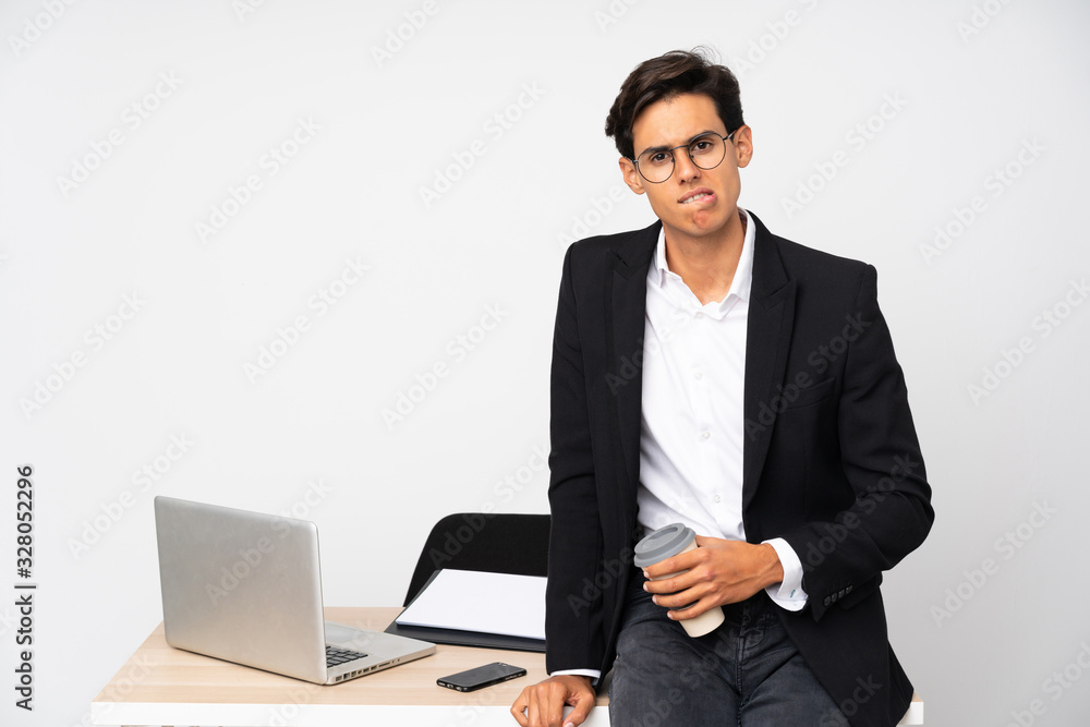 Businessman in his office over isolated white background having doubts and with confuse face expression Businessman in his office over isolated white background having doubts and with confuse face expression