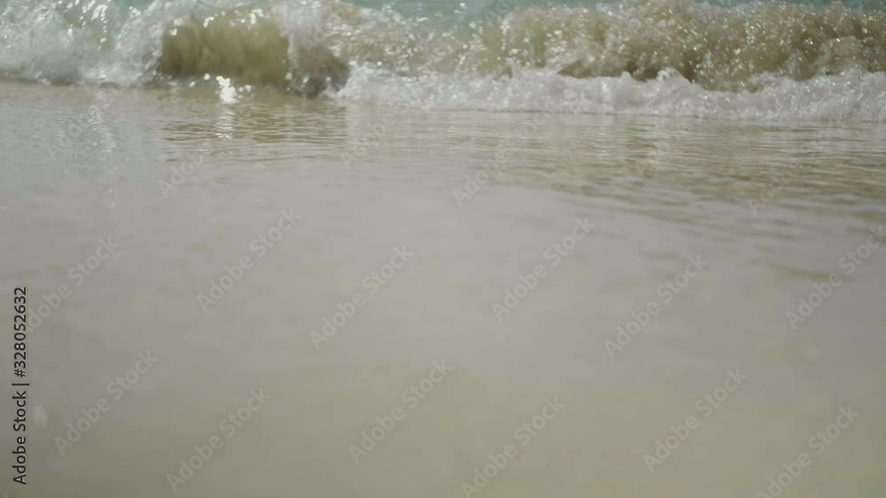 Beautiful close up slow motion view of waves breaking onto the beach