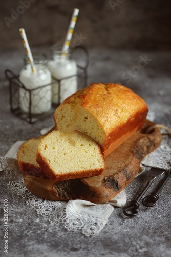 Tasty orange cake with milk on a wooden board. Homemade baking.