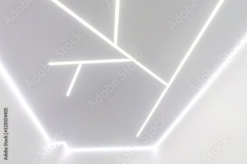 Fototapeta Naklejka Na Ścianę i Meble -  looking up on suspended ceiling with halogen spots lamps and drywall construction in empty room in apartment or house. Stretch ceiling white and complex shape.