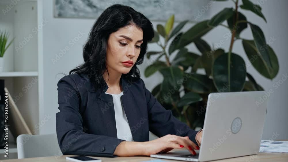 attractive businesswoman working on laptop and suffering from pain in wrist attractive businesswoman working on laptop and suffering from pain in wrist