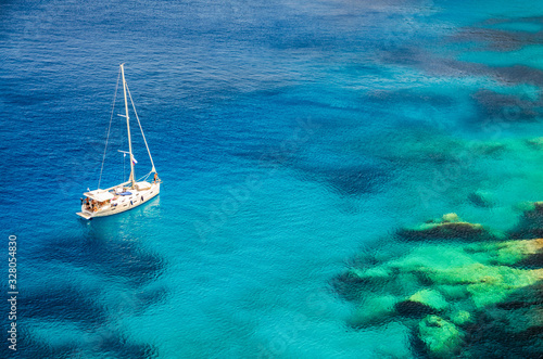 A sailing boat on calm sea on a sunny day in deep blue and turquoise waters in Zakynthos Greece