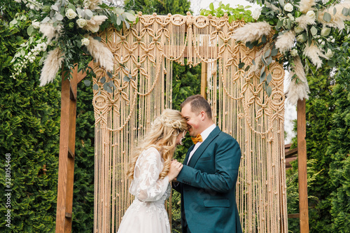 beautiful boho style wedding ceremony. The bride in a beautiful dress and the groom in a classic suit