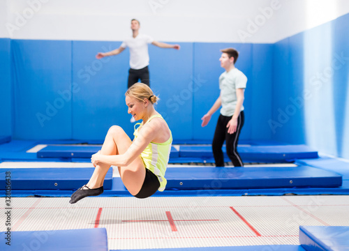 Athletic girl training in trampoline center