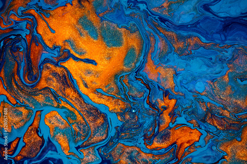 Fluid art texture. Abstract backdrop with mixing paint effect. Liquid acrylic artwork with chaotic mixed paints. Can be used for posters or wallpapers. Blue, orange and golden overflowing colors