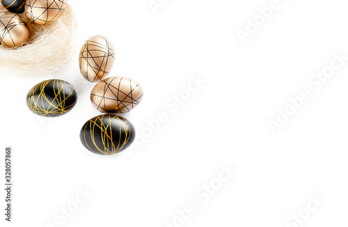 Easter golden decorated eggs in nest on white background . Minimal easter concept copy space for text. Top horizontal view, flatlay.