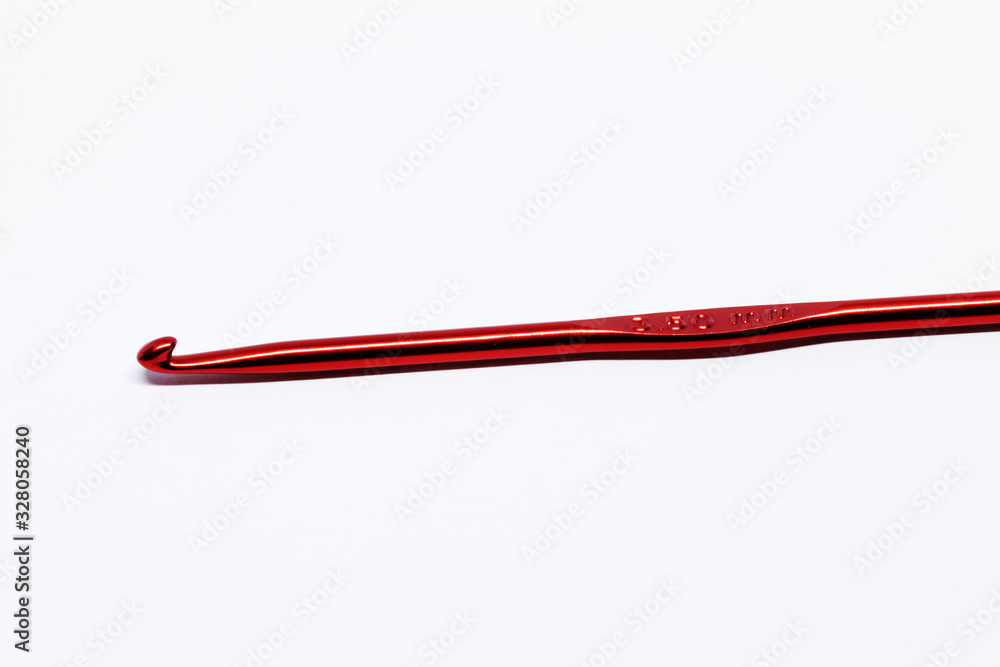 a red crochet hook on white background a red crochet hook on white background